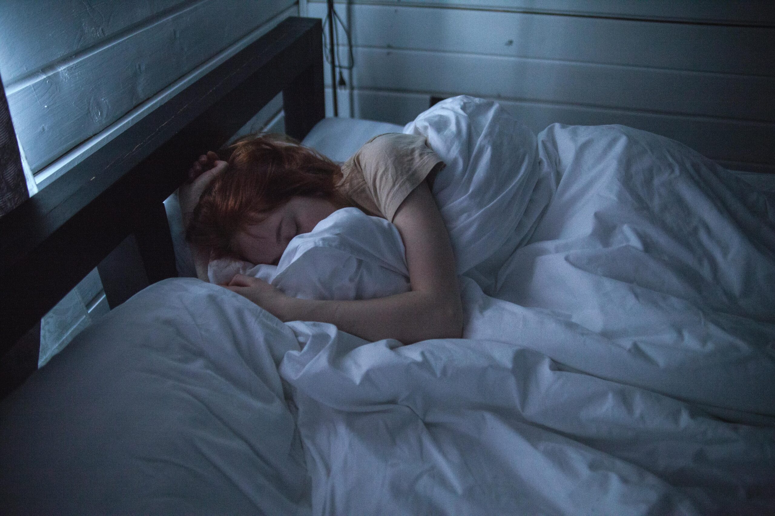 Frau im Bett in dunklem Zimmer